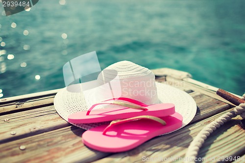 Image of close up of hat and slippers at seaside