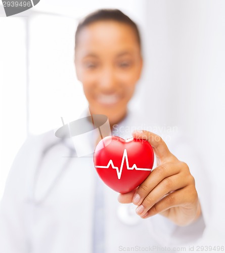 Image of female doctor holding red heart with ecg line