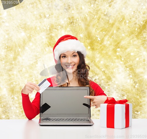 Image of smiling woman with credit card and laptop