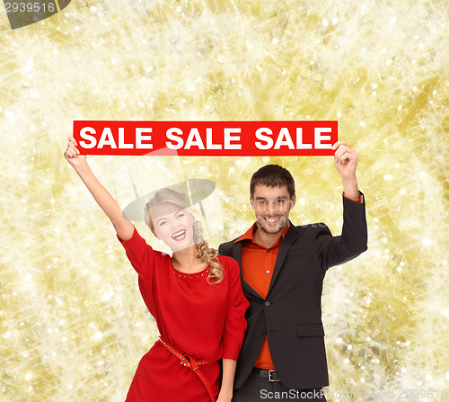 Image of smiling couple with red sale sign