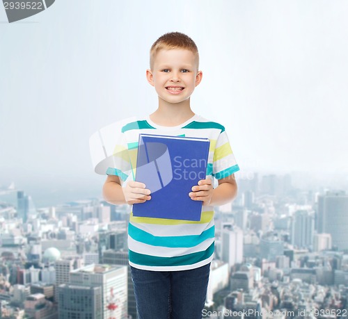 Image of smiling little student boy with blue book