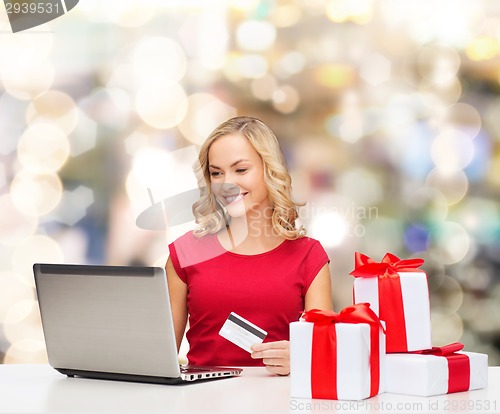 Image of smiling woman with credit card and laptop