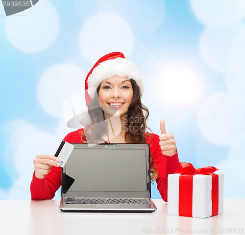 Image of smiling woman with credit card and laptop