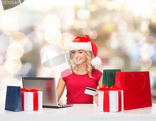 Image of smiling woman with credit card and laptop