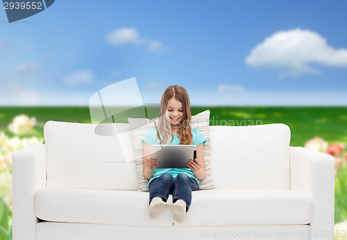 Image of little girl sitting on sofa with tablet pc
