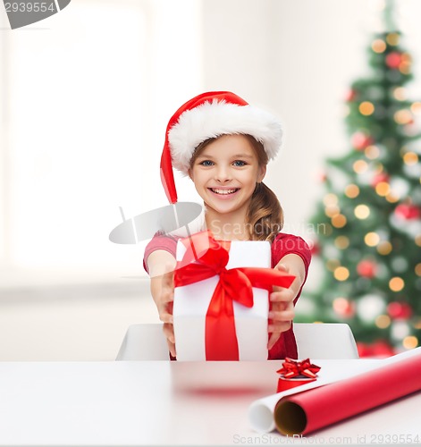 Image of smiling girl in santa helper hat with gift box