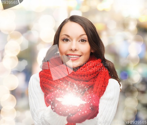 Image of smiling woman in winter clothes with snowflake