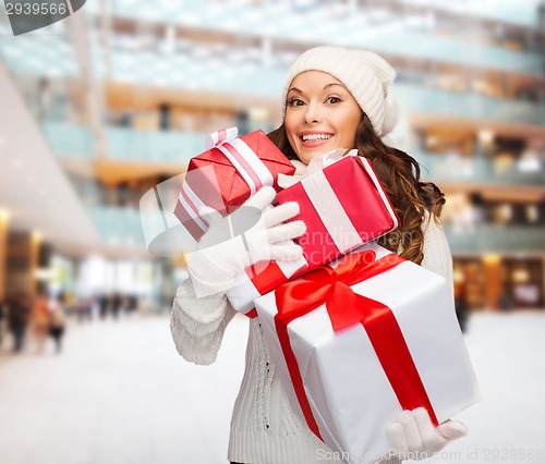 Image of smiling young woman in santa helper hat with gifts