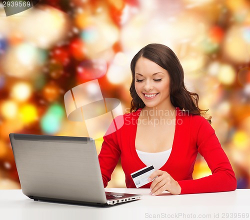 Image of smiling woman with credit card and laptop