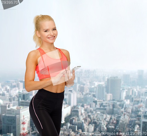 Image of smiling sporty woman with smartphone