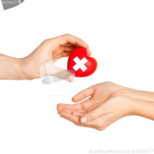 Image of hand giving heart with red cross symbol