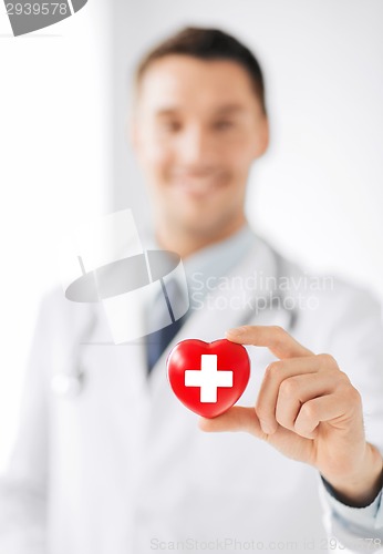 Image of male doctor holding heart with red cross symbol