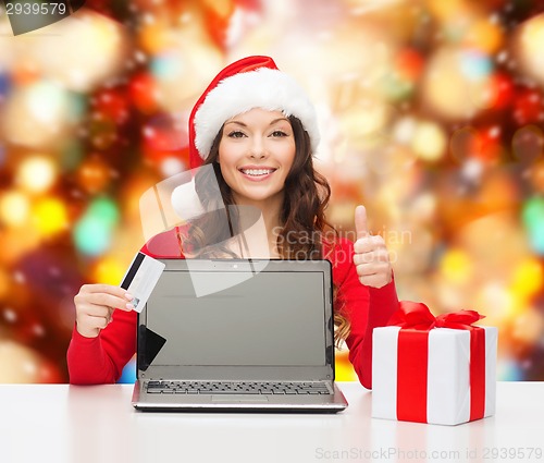 Image of smiling woman with credit card and laptop