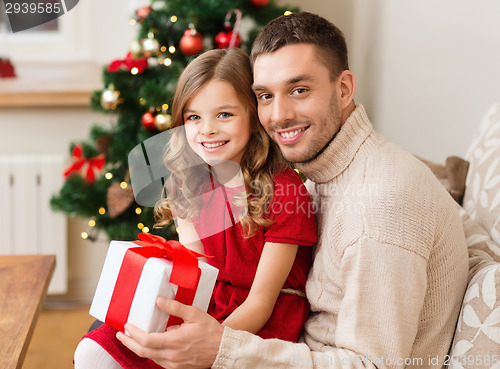 Image of smiling father and daughter holding gift box