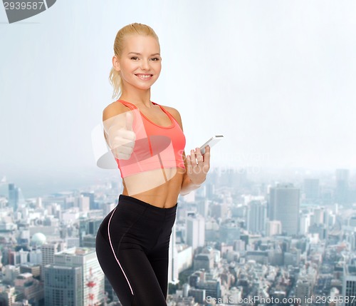 Image of smiling sporty woman with smartphone