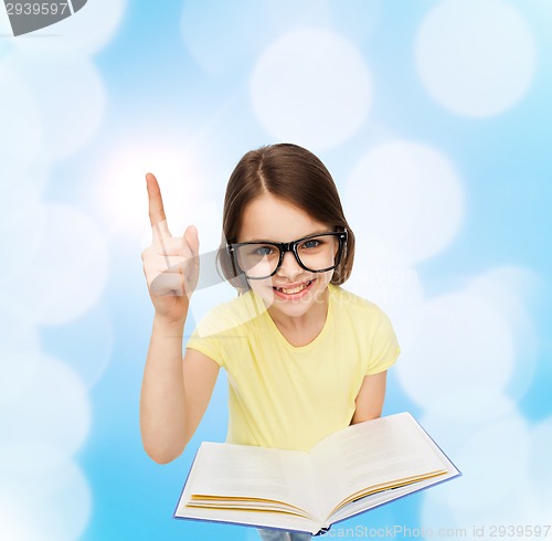 Image of smiling little girl in eyeglasses with book