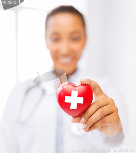 Image of female doctor holding heart with red cross symbol