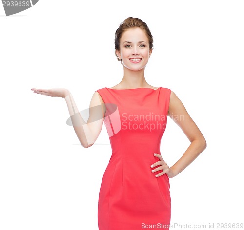 Image of smiling woman holding something imaginary on palm