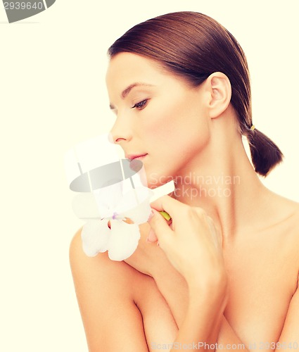 Image of relaxed woman with orchid flower