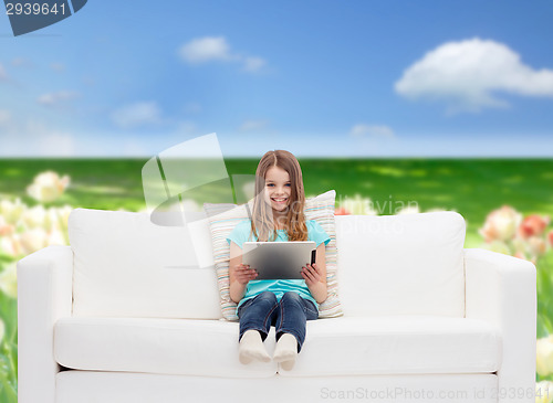 Image of little girl sitting on sofa with tablet pc