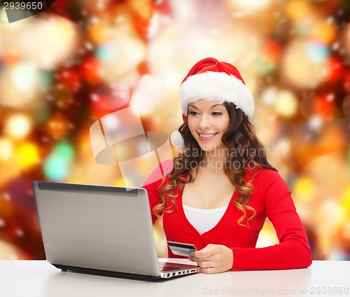 Image of smiling woman with credit card and laptop