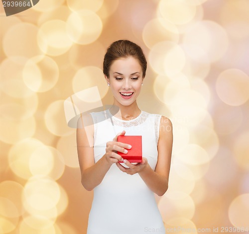 Image of smiling woman holding red gift box