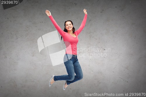 Image of smiling young woman jumping in air