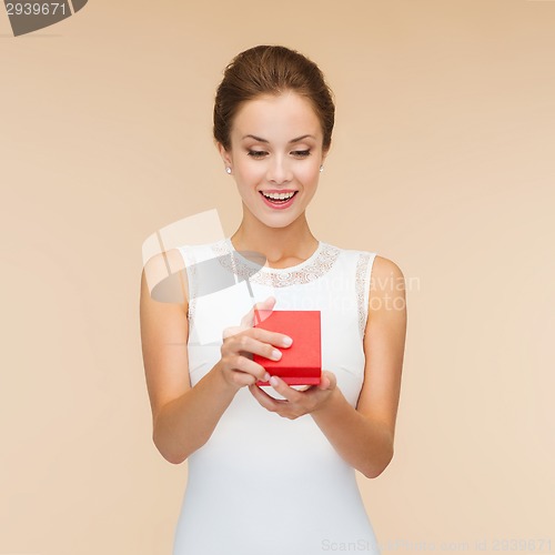 Image of smiling woman holding red gift box