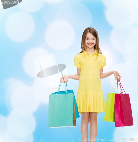 Image of smiling little girl in dress with shopping bags