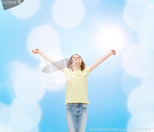 Image of smiling teenage girl with raised hands
