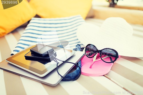 Image of close up of tablet pc and smartphone on beach