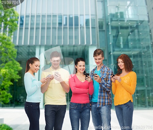 Image of group of smiling teenagers with smartphones