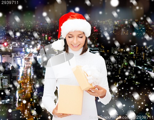 Image of smiling woman in santa helper hat with gift box