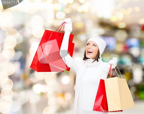 Image of smiling young woman with red shopping bags