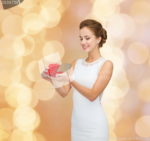 Image of smiling woman holding red gift box