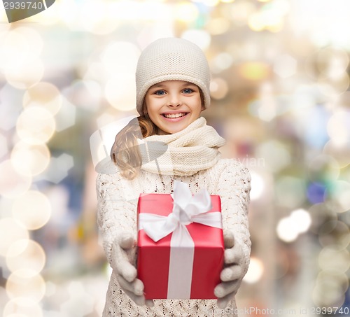 Image of dreaming girl in winter clothes with gift box