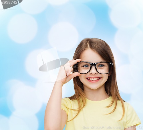 Image of smiling cute little girl in black eyeglasses