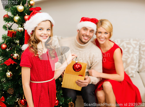 Image of smiling family decorating christmas tree