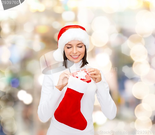 Image of woman in santa hat with gift box and stocking