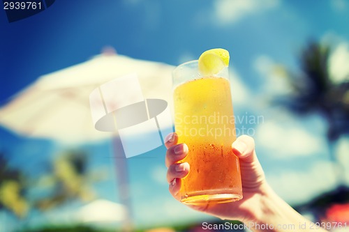 Image of close-up of hand holding glass with cocktail