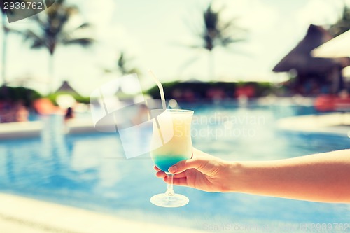 Image of close-up of hand holding glass with cocktail