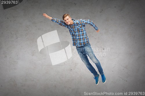 Image of smiling young man jumping in air