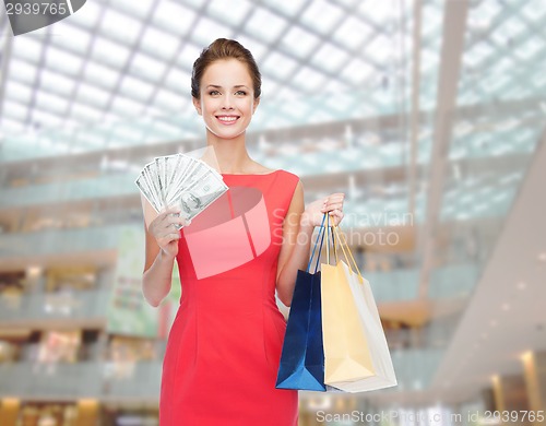 Image of smiling elegant woman in dress with shopping bags