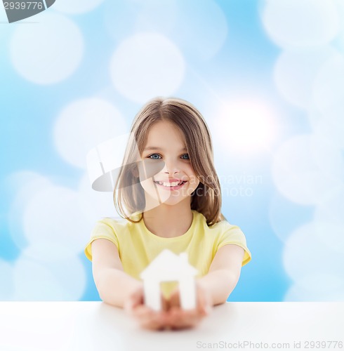 Image of beautiful little girl holding paper house cutout