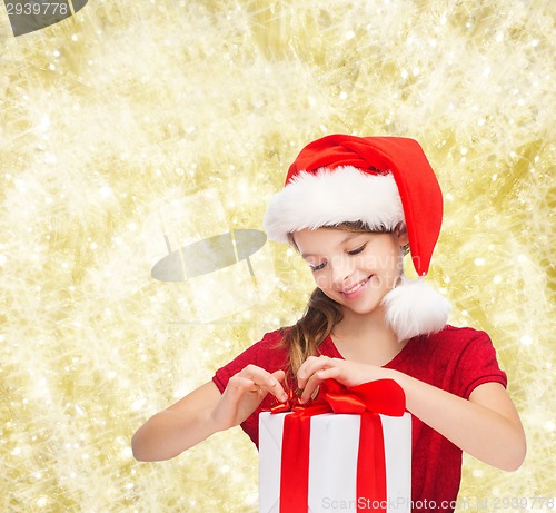 Image of smiling girl in santa helper hat with gift box