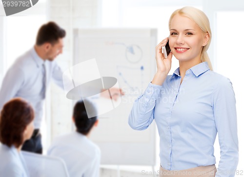 Image of young smiling businesswoman with smartphone