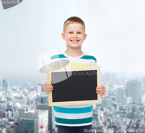 Image of smiling little boy holding blank black chalkboard