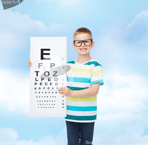 Image of smiling boy in eyeglasses with white blank board