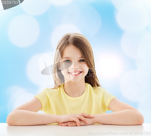 Image of beautiful little girl sitting at table
