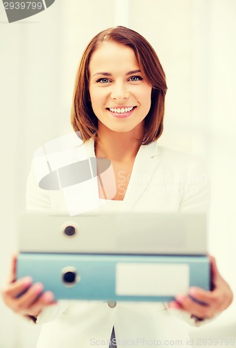 Image of businesswoman with folders in office